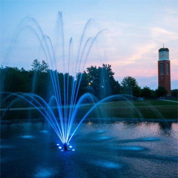 尊伯格池喷泉在黄昏时分被照亮了蓝色，背景是卡里翁塔